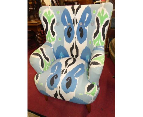 A contemporary bright coloured button back armchair, raised on turned and tapering beech supports, width 80cm