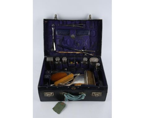 A blue leather dressing case by Drew & Sons, Piccadilly Circus with various contents to include, four silver topped jars, two