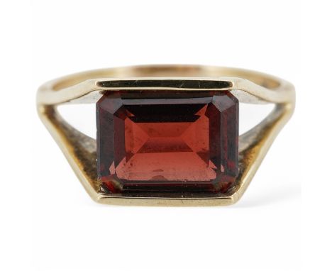 A garnet ring, set with a step-cut garnet, to a textured gold mount, size U1/2, stamped 9ct, gross weight approximately 5 gra