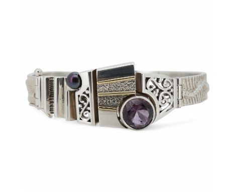 A contemporary silver and amethyst bangle, of abstract, Cubist-inspired design, to a textured band, set with a circular-cut a