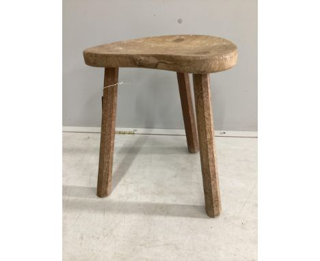 Robert Thompson, 'The Mouseman', a carved oak three legged stool, width 36cm, depth 32cm, height 45cm. Condition - poor, one 
