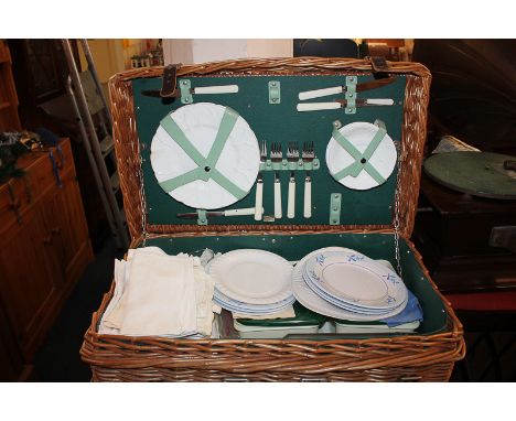 A cane picnic hamper, fitted with various plates, cutlery boxes and linen