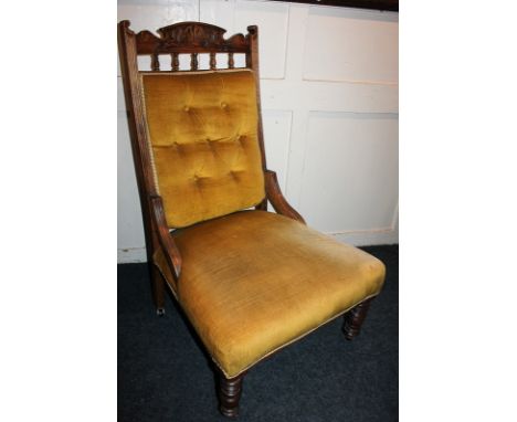 A carved mahogany framed fireside chair,  with button upholstered back and spindle supports, on turned legs and castors