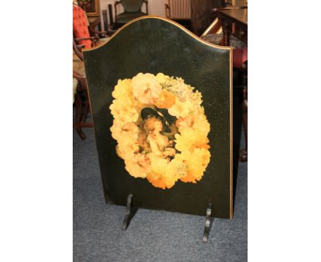 A decorative fire screen, arched shape with portrait of a lady within floral border, on slotted supports, 86cm high