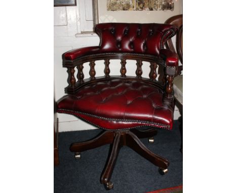 A red leather button upholstered office chair with turned supports, on five splayed legs and castors