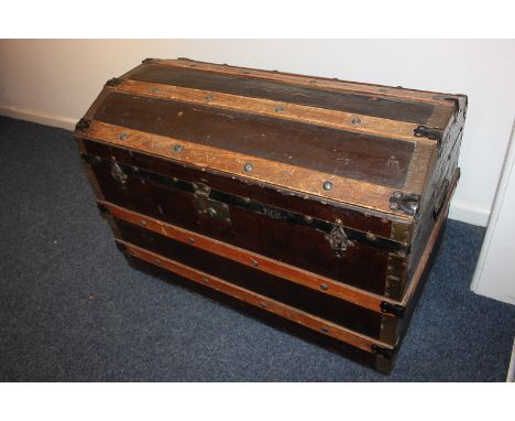 A dome topped trunk with wooden slatted mounts and carry handles, 86cm