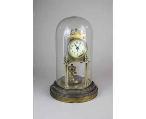 A brass anniversary clock, under glass dome on circular base, clock 23cm high
