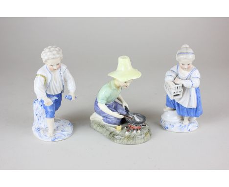 A Royal Doulton porcelain figure, River Boy, HN2128, and a pair of Sitzendorf figures of children with birds and birdcage, 12