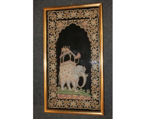 An Indian velvet panel depicting an elephant with stylised floral surround, embroidery and beadwork, in glazed frame, 70cm by