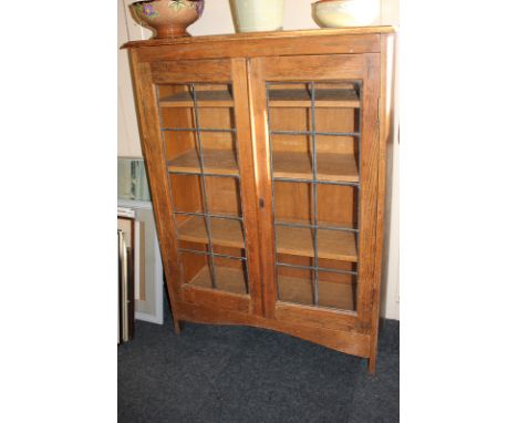 A 20th century oak bookcase with twin lead glazed panel doors enclosing three shelves, on bracket feet, 90cm