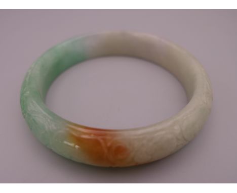 A carved jade bangle.  6.25 cm inner diameter. 