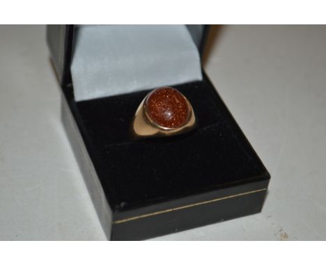 A yellow metal aventurine set ring