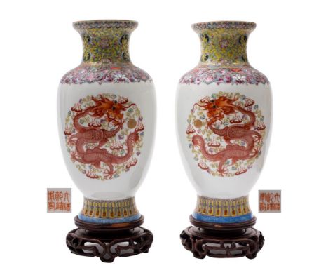 A pair of Chinese famille rose dragon vases: painted with dragons chasing gilt pearls amongst flame and cloud scrolls, the ri