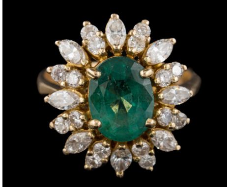 An emerald and diamond oval cluster ring: the central, four-claw-set oval emerald approximately 10mm x long x 7.5mm wide x 5.