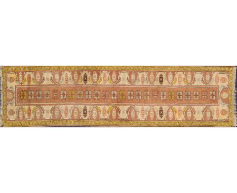 A Turkish runner:, the light brown rectangular panel with a row of serrated stellar medallions, beige and light brown geometr