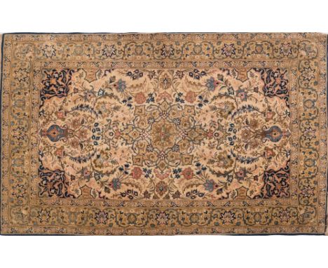 A Tabriz rug:, the beige cartouche field with a central light brown geometric pole medallion, all over palmette and floral fo