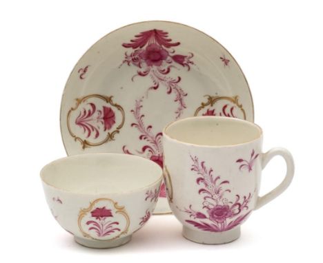 A First Period Worcester trio: painted in puce camaieu with floral sprays, foliage and gilt cartouches in the Meissen manner,