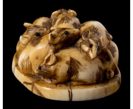 A Japanese carved ivory netsuke: of a group of rats, signed to the oval back Meizen, 3cm. wide.