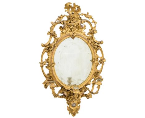 A 19th Century carved giltwood and gesso oval girandole mirror:, with rocaille and acanthus scroll cresting hung with vine le