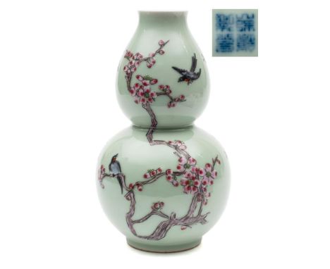 A Chinese famille rose double gourd vase: painted with birds and branches of pink blossom on a celadon ground, underglaze blu