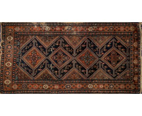 A Melayer rug:, the indigo field with four serrated lozenge and geometric flowerhead medallions, arrow designs and triangular