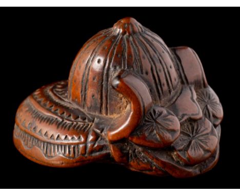 A Japanese carved boxwood netsuke of a kabuto: of traditional design, unsigned, 4cm. wide, Meiji period.