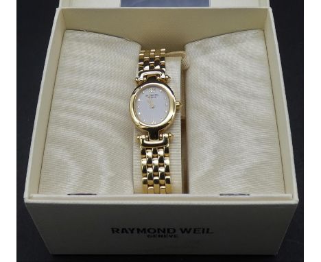 A boxed Raymond Weil gold plated ladies wristwatch with papers. It has an oval face with white enamel dial and articulated br