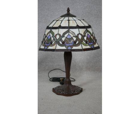 A Tiffany style table lamp with leaded coloured glass panels and tulip motifs to the base. H.55cm 