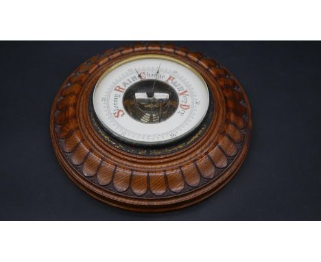A C.1900 oak cased barometer with well carved sunburst decoration. D.23.5cm 