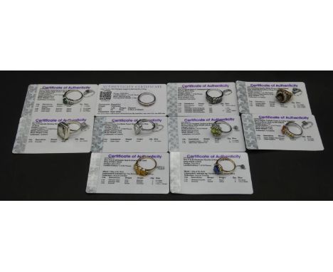 Ten gemstone set rings with certificates. To include a 9ct yellow gold Ethiopian opal and emerald three stone ring, a Kyanite