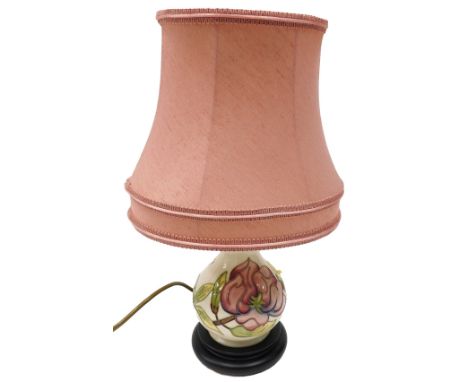 A Moorcroft table lamp, decorated with the pink flower design, on a cream ground with pink shade, 38cm high.