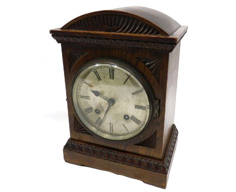 An early 20thC oak mantel clock, the silvered dial with ebonised Roman numerals, 21cm high.