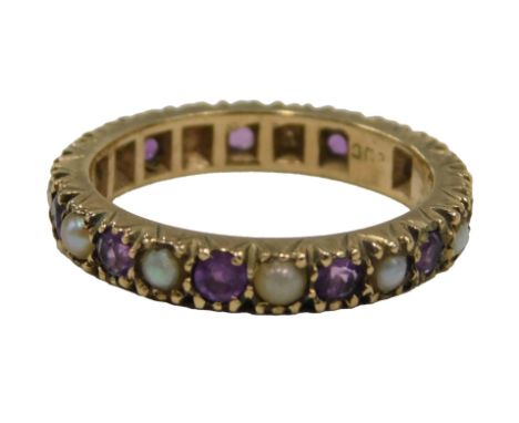 A 9ct gold amethyst and seed pearl eternity ring, two stones missing, ring size K, 2.6g.