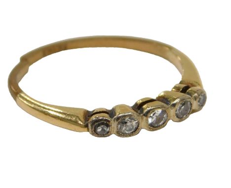 A diamond five stone dress ring, set with five tiny diamonds in rub over setting, on a yellow metal band, stamped 18ct, cut, 