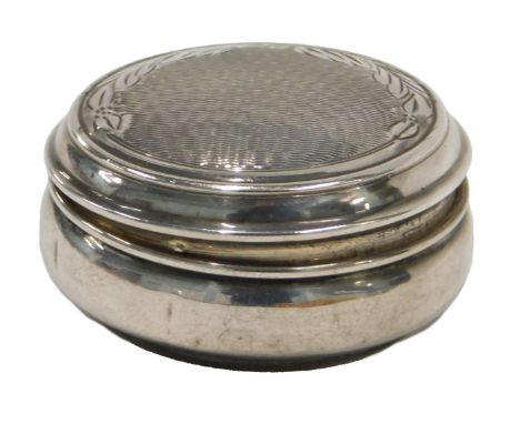 An Elizabeth II silver pill box, with engine engraved leaf top, 0.45oz, hallmarks rubbed.