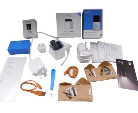 A Ring doorbell charging station and single battery, various cabling and empty Ring doorbell boxes.