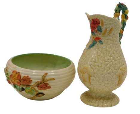 A Clarice Cliff relief moulded harvest jug, printed marks to underside, and a relief moulded bowl, (AF). (2)