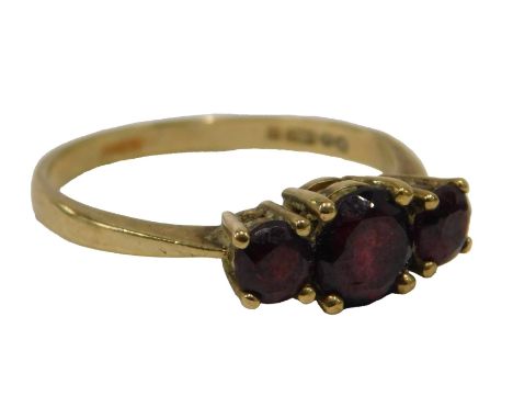 A 9ct gold three stone dress ring, set with three round brilliant cut garnets, in raised claw basket setting, ring size P½, 2