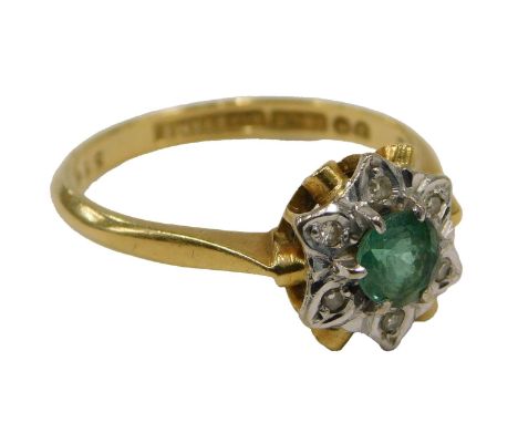 An emerald and diamond cluster ring, set with round brilliant cut emerald, in six claw setting, surrounded by six tiny diamon
