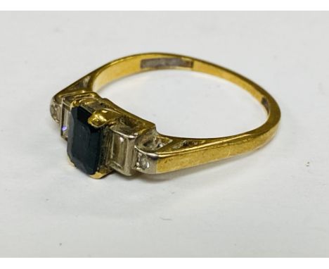 An 18ct gold sapphire set ring flanked by 2 baguette cut diamonds.