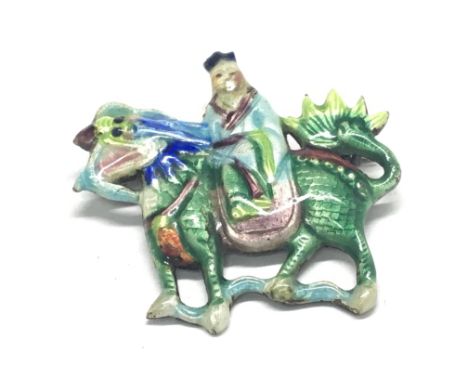 A Vintage Chinese silver and enamel brooch a figure with a dragon. 5cm wide. No obvious damage.
