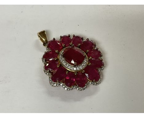 A sterling silver gilt ruby and white stone pendant.