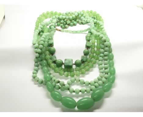 A collection of four jade and conforming stone graduating bead necklaces some long strand one with alternating square cuts. (