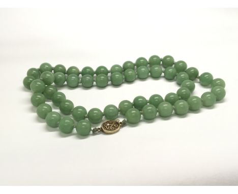 A Vintage jade bead necklace with a filigree clasp.