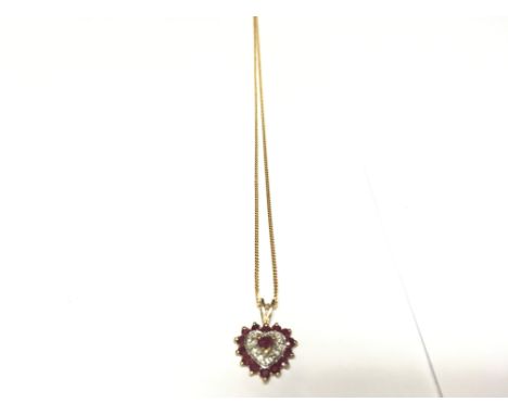 A ruby and diamond heart pendant suspended from yellow gold chain.