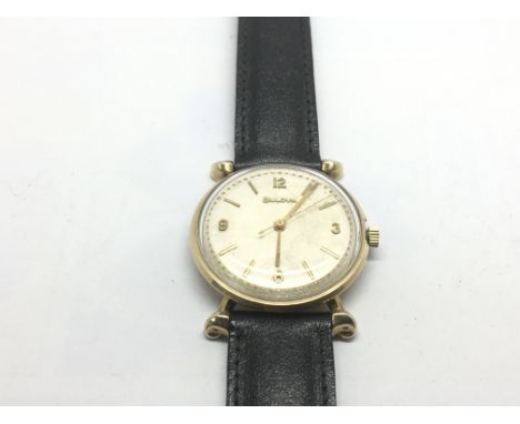 A vintage Bulova watch with baton and Arabic numerals.