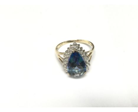 A pear shaped blue topaz with diamond cluster. Size R-S.
