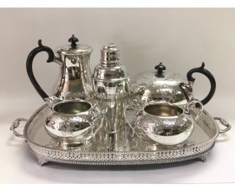 A silver plated tea set, a galleried tray and a cocktail shaker.