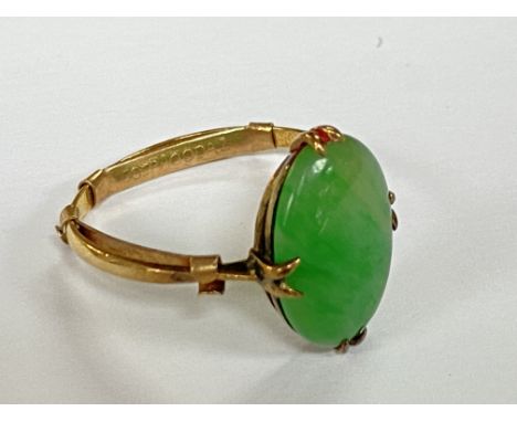 An unmarked gold ring set with a jade stone.