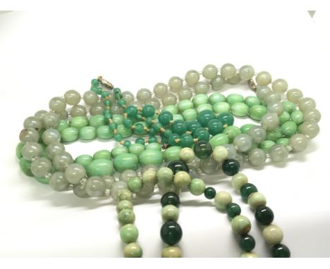 A collection of four long vintage green jade and other conforming necklaces. (4)